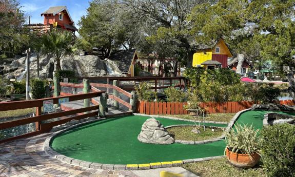 This hole and green has trees and rocks