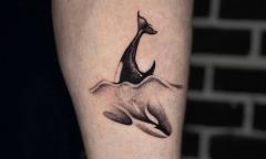 A black and grey whale tattoo