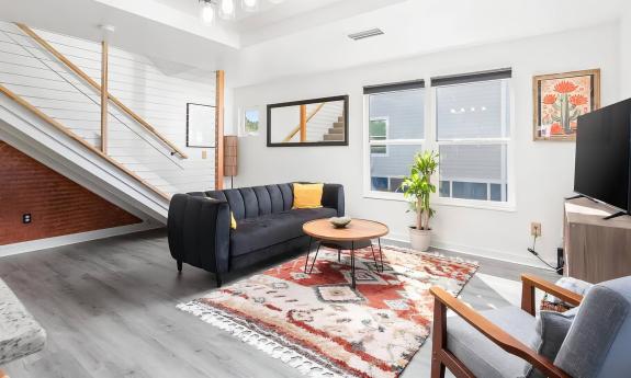 The interior of an Elite Florida Pads vacation property with a living area and stairs to the next level