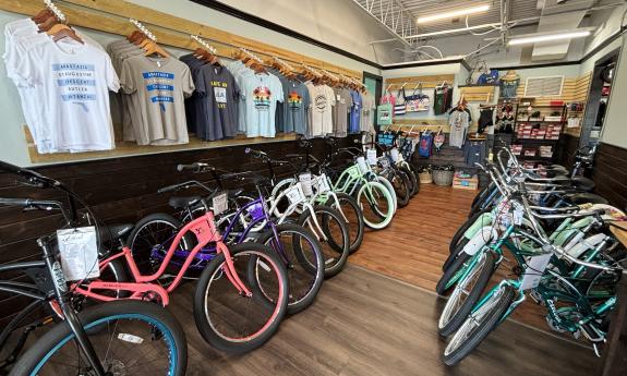 Bikes for sale lined up in two rows, with shirts and accessories displayed above
