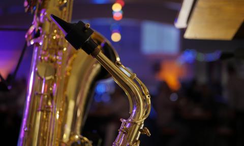 A close up of several saxophones lit on stage