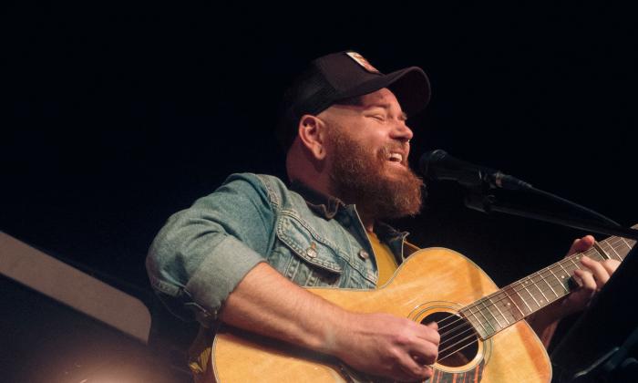 Musician Kirk Whalen playing his guitar, laughing