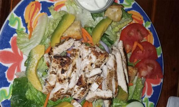 A specialized salad with grilled chicken and avocado
