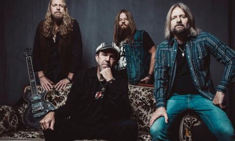 Bandmates from The Steepwater Band pose in front of a dark gray backdrop.