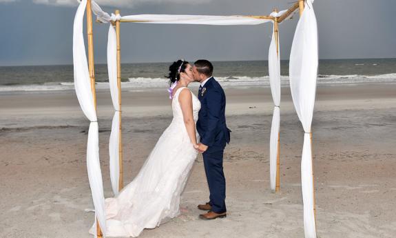kissing under a curtain canopy