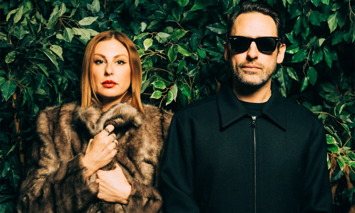 Phantogram’s bandmates strike a pose in front of a vibrant wall of greenery.